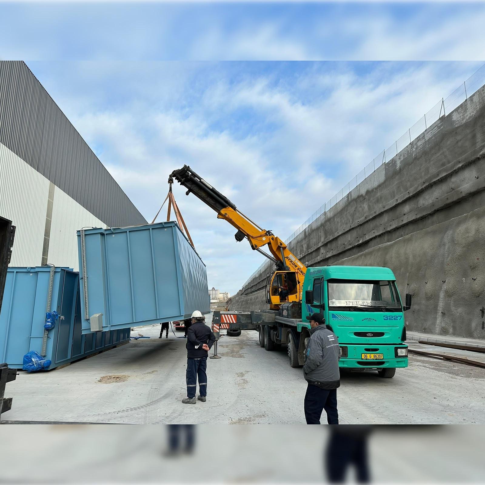 Kamyon üstü vinçle sahada kaldırılan büyük metal ekipman