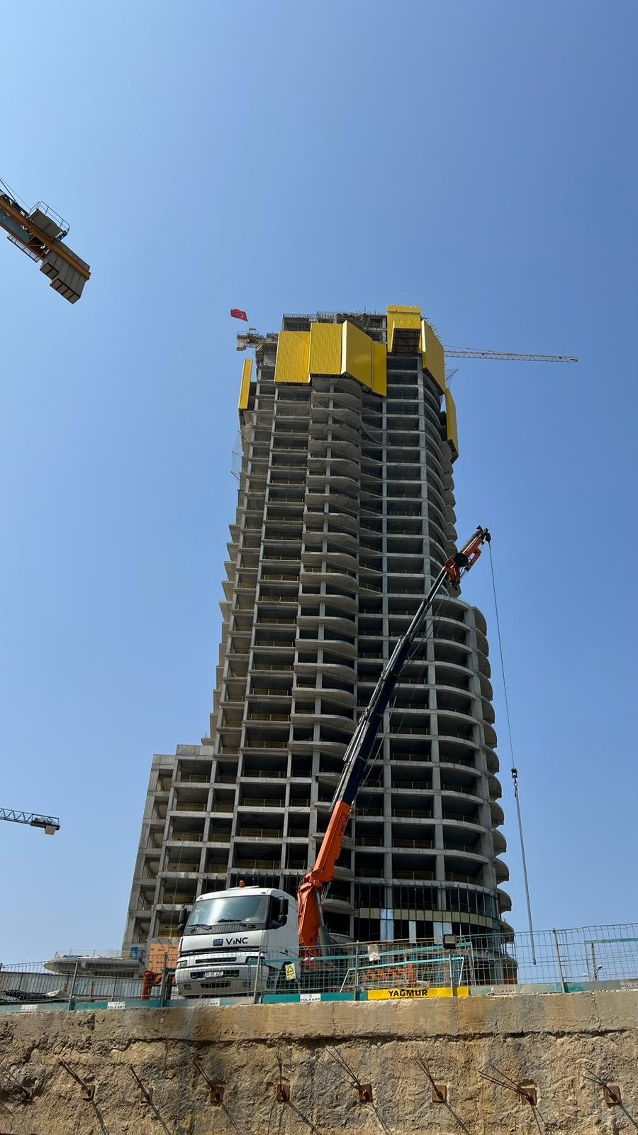 Yüksek yapı şantiyesinin önünde kurulmuş kamyon üstü vinç